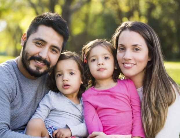 Family of four sitting in grass