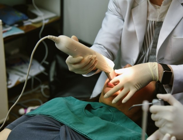 Dentist taking digital impressions of teeth