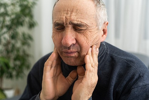 Dentures patient in Westerville rubbing their cheeks