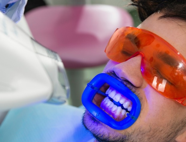 Man getting professional teeth whitening in dental office