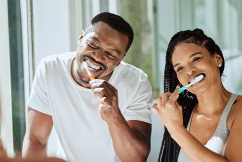 a couple brushing their teeth in the morning