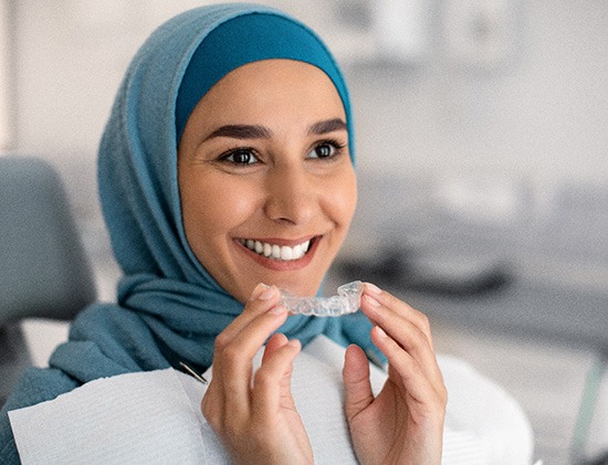 Closeup of dentist putting clear aligner on patient