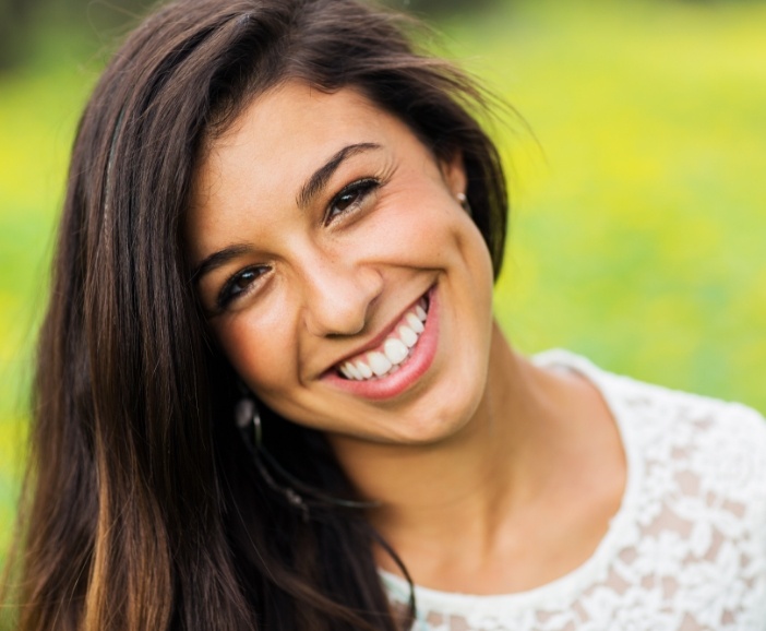 Young woman grinning outdoors after teeth whitening in Westerville