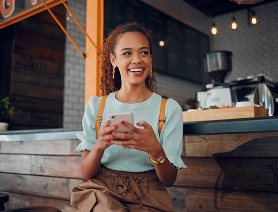 Smiling woman sitting on barstool at restaurant