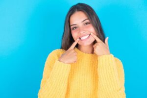 Smiling woman pointing at her teeth