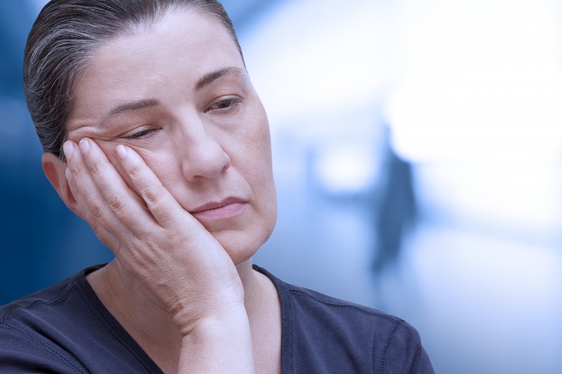 Patient holding their cheeks due to dental emergencies